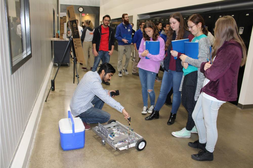 project designer showing their robot to students